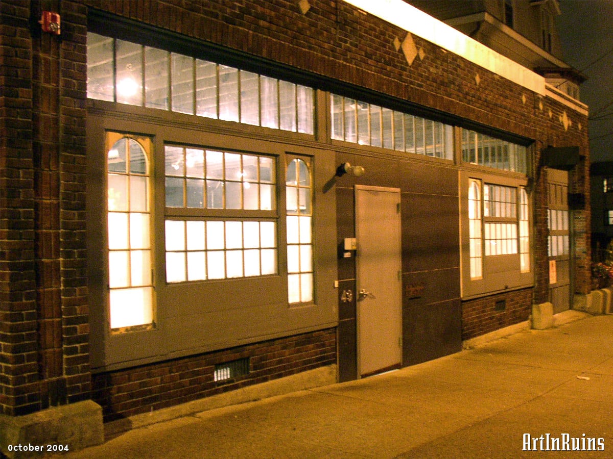 A one story red brick former commercial storefront with garage and storeroom. Additional description in the historical notes.