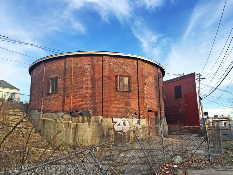 View of the round gasometer with retort builing in the back